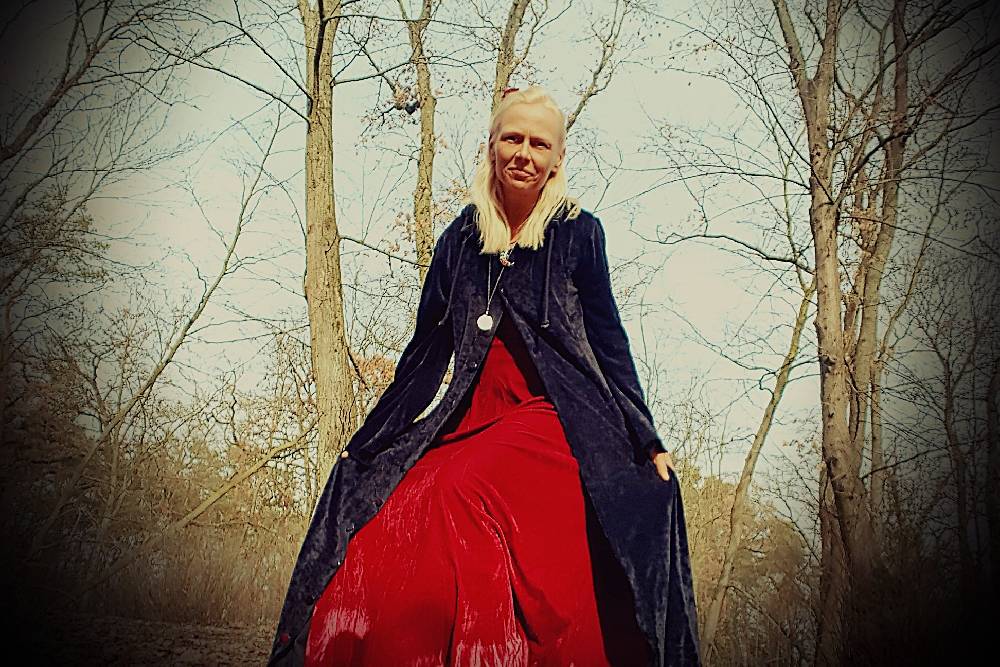 Bin ich im winterlichen Wald zusehen mit rotem Kleid und schwarzem Mantel.