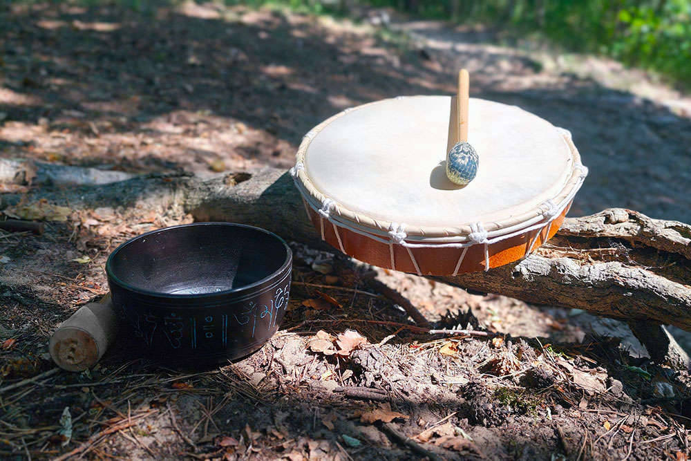 Klangschale und Trommel auf dem Waldboden